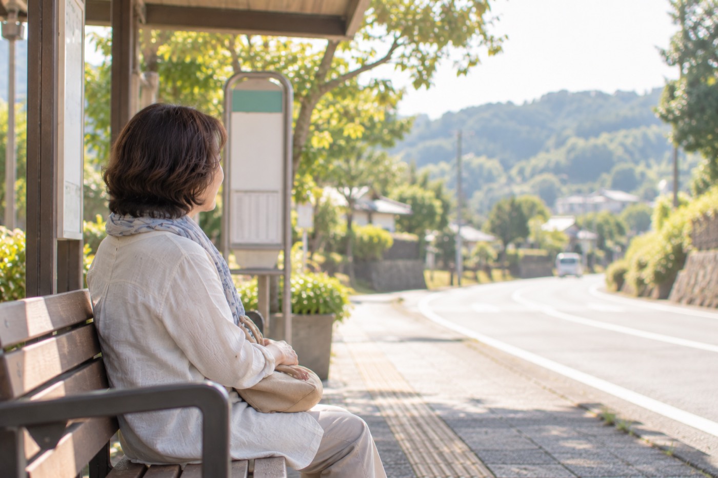 バス停のベンチで待つ女性